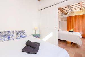 a bedroom with a white bed with a towel on it at Casa de Ses Roques in Ciutadella