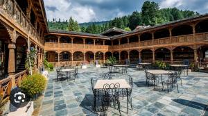 a courtyard with tables and chairs in a building at MHA hotel ever green manali in Manāli