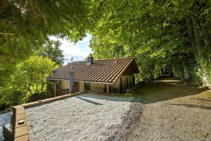a house with a gravel driveway in front of it at Ferienhaus am Wald mit Südblick in Steina