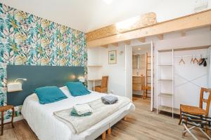 a bedroom with a large bed with blue pillows at Gite La Grange Hulotte in Chaillé-les-Marais