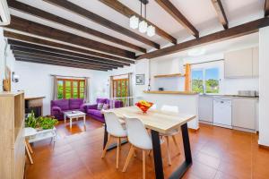 a kitchen and living room with a table and chairs at Can Amer in Pollença