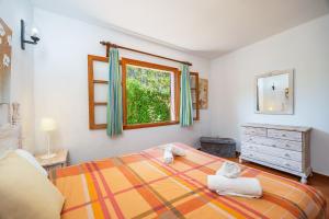 a bedroom with a bed and a window and a dresser at Can Amer in Pollença +21 photos