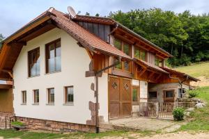 a house with a gambrel roof and wooden doors at Ferienwohnung Burgblick in Biberach