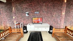 a living room with a tv and two benches at Villa Kay Height in Kopo 2 +13 photos