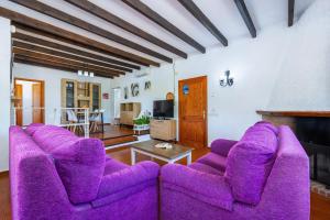 a living room with purple chairs and a fireplace at Can Amer in Pollença