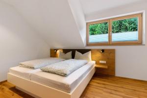 a bedroom with two beds and two windows at Ferienwohnung Burgblick in Biberach