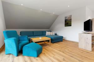 a living room with blue chairs and a table at Ferienwohnung Burgblick in Biberach