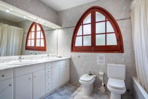 a bathroom with two sinks a toilet and two windows at Tresa in Lloret de Mar +22 photos
