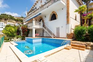 a villa with a swimming pool and a house at Tresa in Lloret de Mar