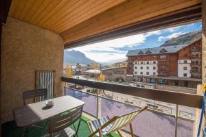 a balcony with a table and chairs and a view at Serre-chevalier Vallée - Briançon in Briançon