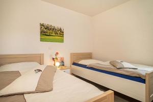 a bedroom with two beds and a painting on the wall at Haus Afaldra in Mengen
