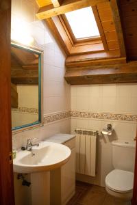 a bathroom with a sink and a toilet with a skylight at Kabila Enea 2 in Uztárroz +11 photos