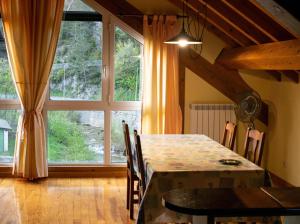 a dining room with a table and a large window at Kabila Enea 2 in Uztárroz