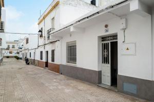 an empty alley with a white building and a door at Piso Pablo in Barbate