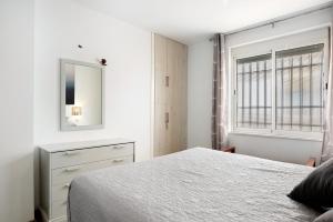 a bedroom with a bed and a dresser and a mirror at Piso Pablo in Barbate