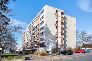 a tall white building with cars parked in a parking lot at Al Mare in Wunstorf