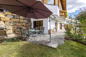 a table and chairs with an umbrella in a yard at Südalb in Albstadt