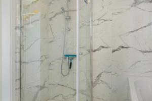 a bathroom with a shower with marble walls at Luxusvilla Neubau 1 in Oberasbach +29 photos