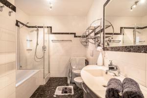 a white bathroom with a sink and a shower at Apartement Santner in Siusi +24 photos