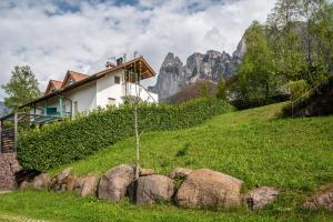 a house on the side of a hill with rocks at Apartement Santner in Siusi