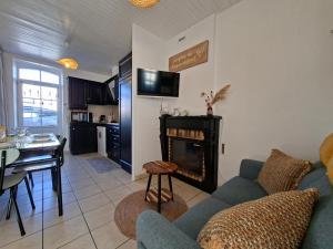 a living room with a couch and a fireplace at L'instant Terrière,maison de charme in La Tranche-sur-Mer