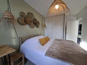 a bedroom with a bed and some hats on the wall at L'instant Terrière,maison de charme in La Tranche-sur-Mer