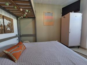 a bedroom with a bed and a refrigerator at L'instant Terrière,maison de charme in La Tranche-sur-Mer