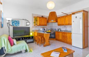 a kitchen with wooden cabinets and a white refrigerator at Casita Isabella in El Golfo +16 photos