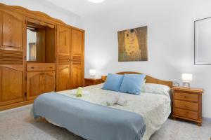 a bedroom with a large bed with blue pillows at Casita Isabella in El Golfo