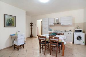 a kitchen with a table and chairs in a kitchen at Il Frutteto 50 in Ortovero