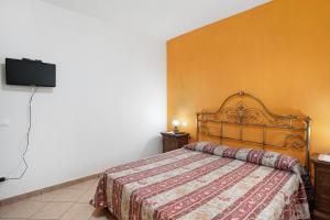 a bedroom with a bed and a flat screen tv at Il Frutteto 50 in Ortovero