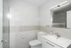 a white bathroom with a toilet and a sink at Casa Chana in Almuñécar +22 photos