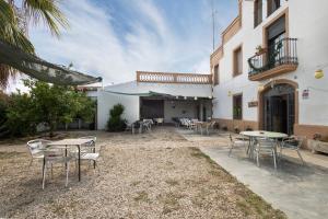 a patio with tables and chairs in front of a building at Masia Cal Vies in Castellví de la Marca