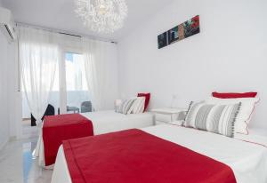 a white room with two beds and a chandelier at Casa Chana in Almuñécar