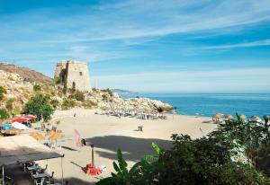 a beach with a castle on top of a hill at Casa Chana in Almuñécar