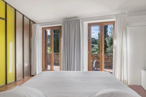 a bedroom with a large bed and large windows at Cortijo La Almazara in Ronda +33 photos