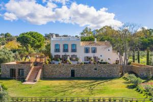 an exterior view of a house with a stone wall at Cortijo La Almazara in Ronda