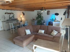 a living room with a brown couch and a kitchen at Séjour Nature à Campan in Campan