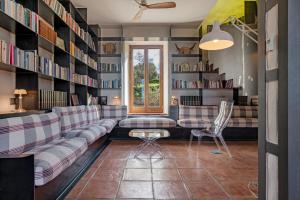 a living room with a couch and bookshelves at Cortijo La Almazara in Ronda