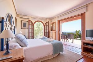 a bedroom with a bed and a television and a balcony at Villa Arcadia in San Jose