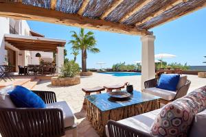 a patio with a table and chairs and a pool at Villa Arcadia in San Jose