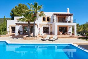a villa with a swimming pool in front of a house at Villa Arcadia in San Jose
