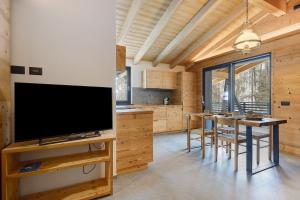 a living room with a large television and a table with chairs at Luxury Ossana in Fucine