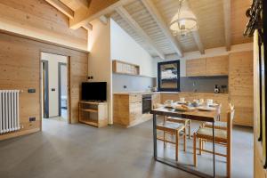 a large kitchen with a table and a television at Luxury Ossana in Fucine