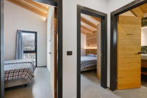 a bedroom with two beds and a door with a window at Luxury Ossana in Fucine