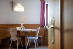 a dining room table with two chairs and a vase on it at Apartment 2 - Zur Sonne in Laion