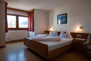 a bedroom with a bed with white sheets and a window at Apartment 2 - Zur Sonne in Laion