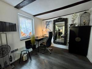 a living room with a desk and a mirror at Kalles Tochter in Melsungen
