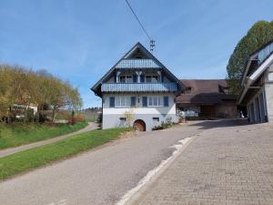 a white house with a black roof on a road at Ferienwohnung Reinbold in Durbach