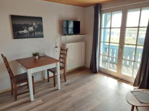 a dining room with a table and chairs and a window at Ferienwohnung Reinbold in Durbach